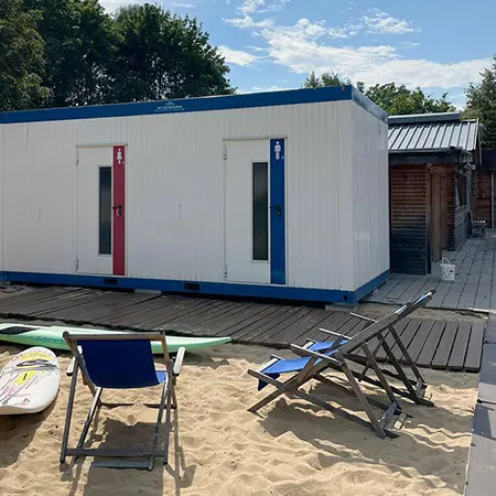 Toilettencontainer am Strand eines Badesees